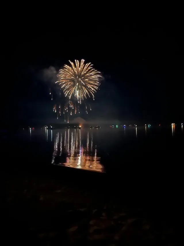A golden fireworks burst reflected in Lake Arbutus.